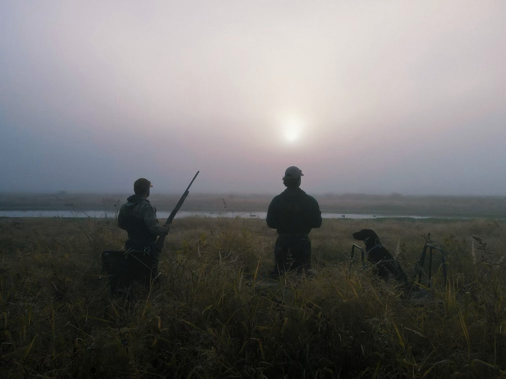 hunters watching sun go down